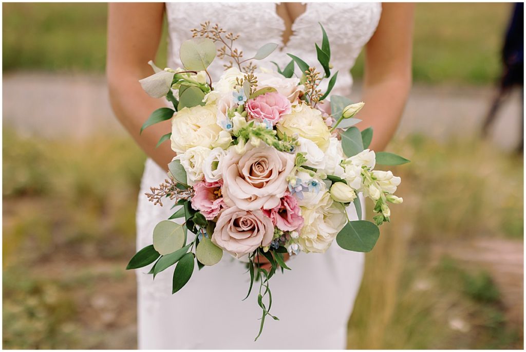 Bride holding bouquet designed by Fancy Pansy.