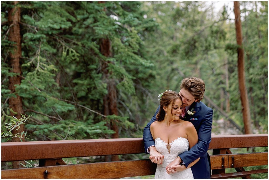 Bride and groom on bridge at Vail mountain. 