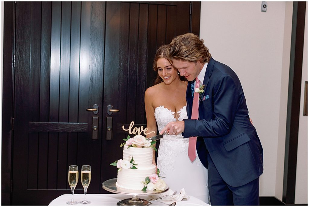 Bride and groom cutting cake designed by Cornerstone Chocolates & Confections.