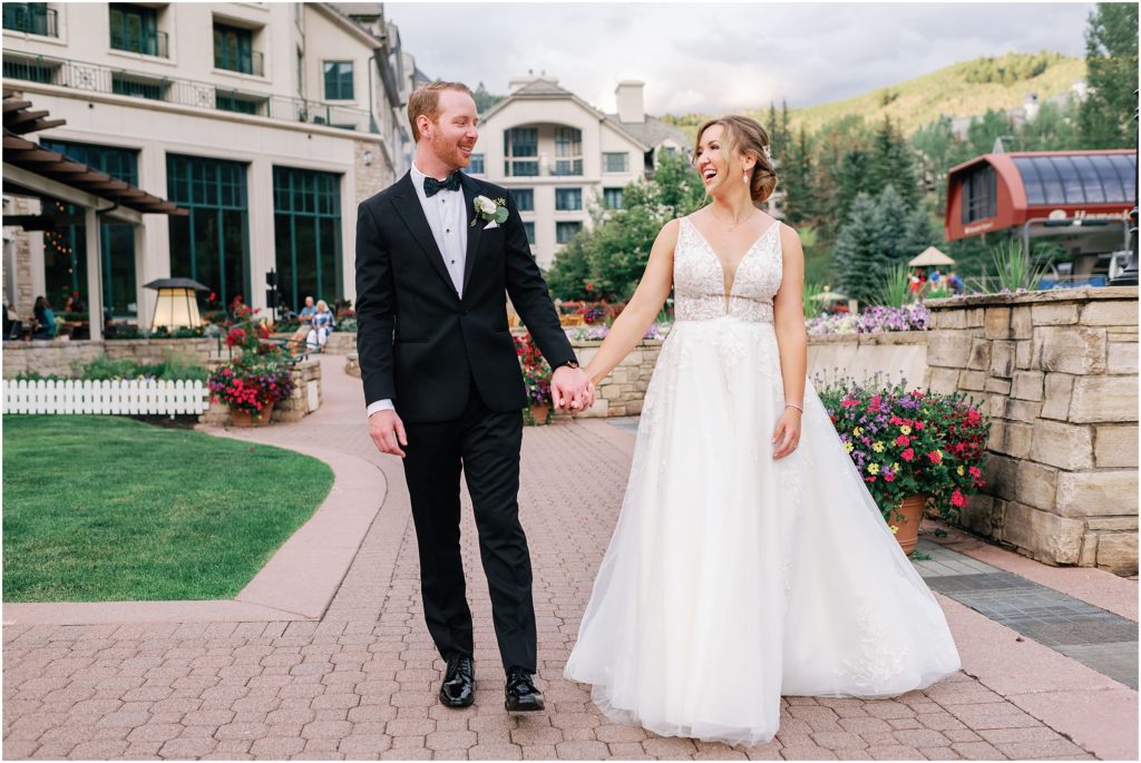 Bride and groom walking outside holding hands at Beaver Creek after ceremony