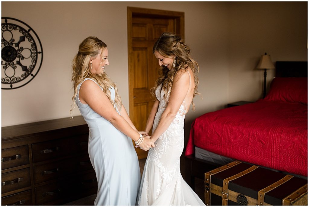 Bride getting wedding dress on from Town and Country Bridal and bridesmaid wearing dress from Amsale