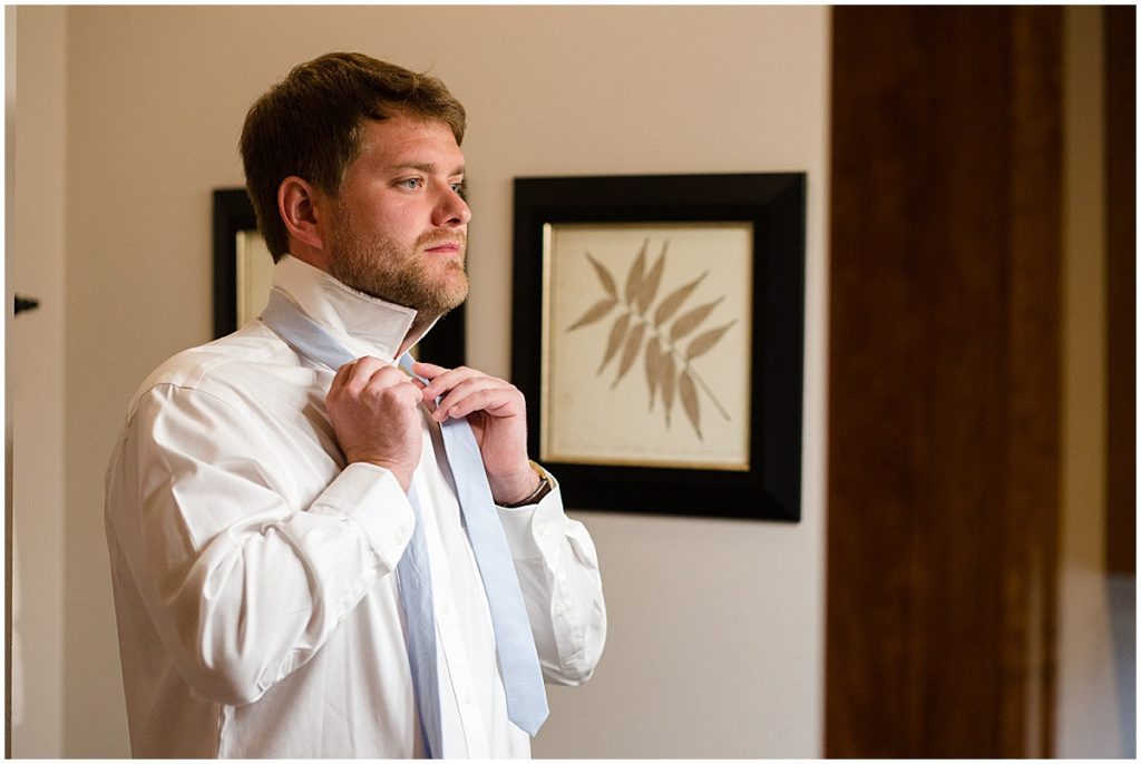 Groom putting on suit from Jos A Bank at the Stanley Hotel in Estes Park