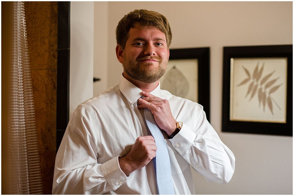 Groom putting on suit from Jos A Bank at the Stanley Hotel in Estes Park