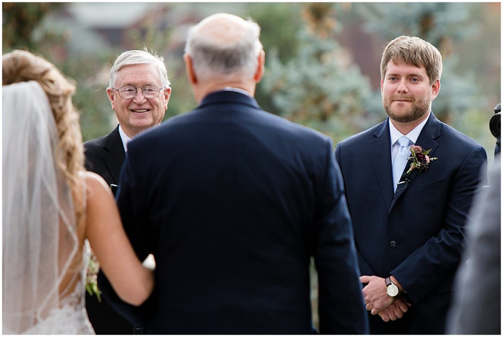 Groom wearing suit from Jos A Bank looking at bride at wedding in the Stanley Hotel in Estes Park.