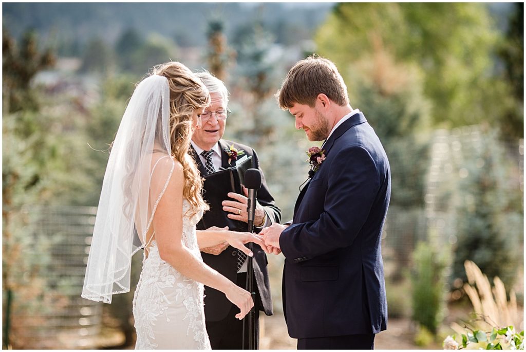 Bride and groom exchanging rings during wedding ceremony at the Stanley Hotel in Estes Park.