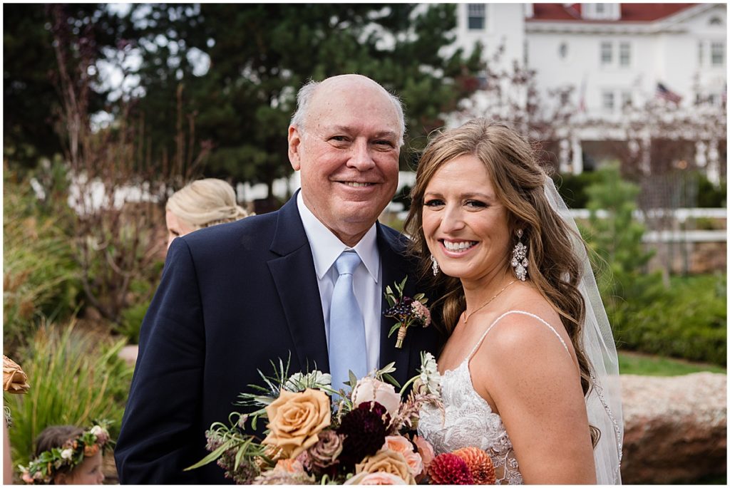 Bride and dad after wedding ceremony at the Stanley Hotel in Estes Park.  Bride holding bouquet from Lace and Lilies Flowers.