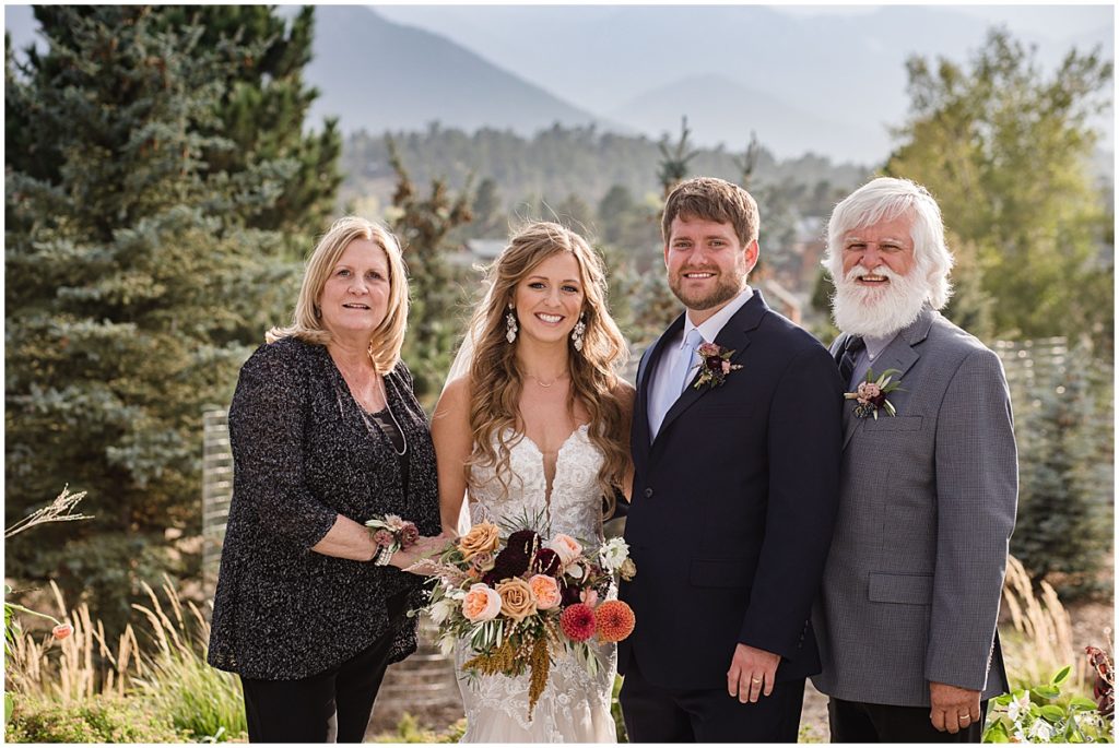 Bride and groom with friends and family at the Stanley Hotel in Estes Park.  Bride is wearing dress from Town and Country Bridal holding bouquet from Lace and Lilies Flowers.  Groom wearing suit from Jos A Bank.