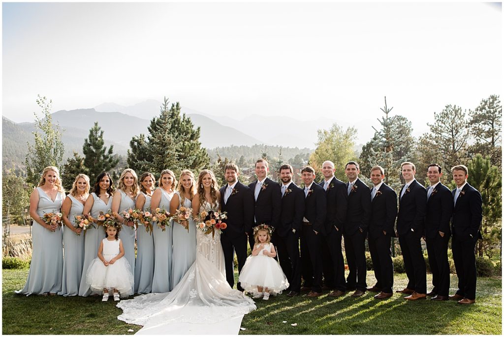 Bride and groom with bridal party at the Stanley Hotel in Estes Park.  Bride is wearing dress from Town and Country Bridal holding bouquet from Lace and Lilies Flowers.  Groom wearing suit from Jos A Bank.