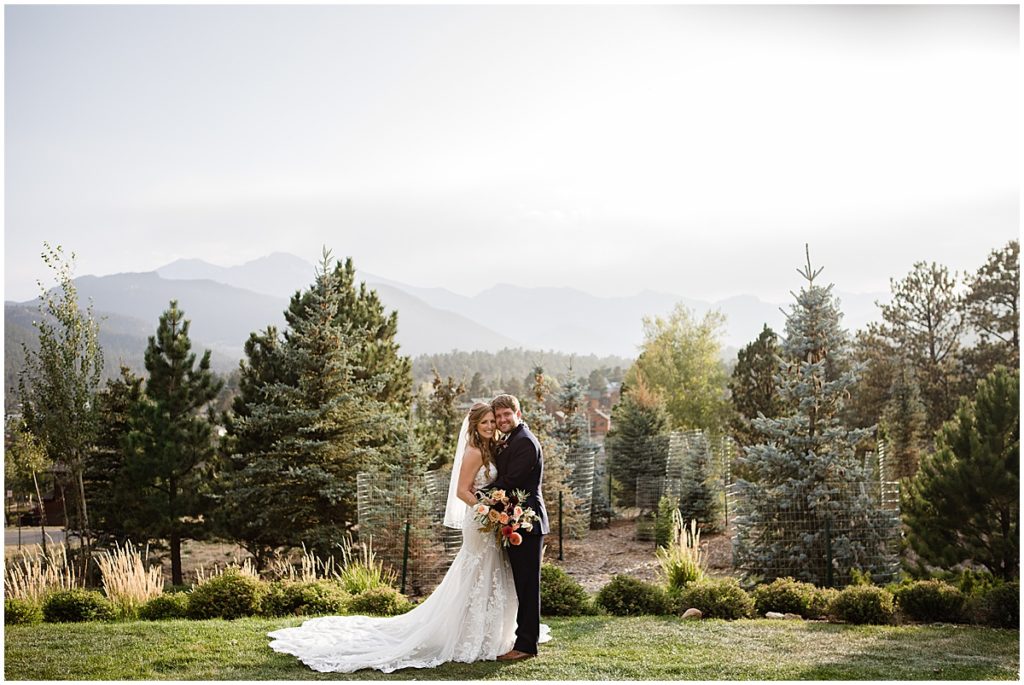 Bride and groom at the Stanley Hotel in Estes Park.  Bride is wearing dress from Town and Country Bridal holding bouquet from Lace and Lilies Flowers.  Groom wearing suit from Jos A Bank.