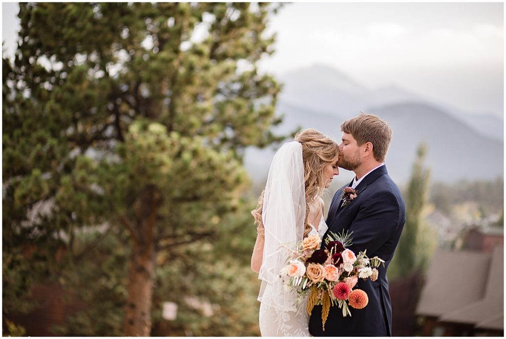 Bride and groom at the Stanley Hotel in Estes Park.  Bride is wearing dress from Town and Country Bridal holding bouquet from Lace and Lilies Flowers.  Groom wearing suit from Jos A Bank.