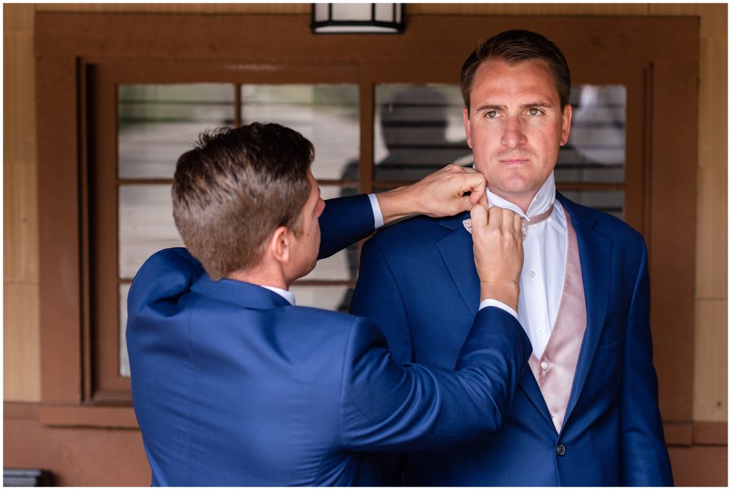 Groom putting on suit at Grand Lake Lodge.