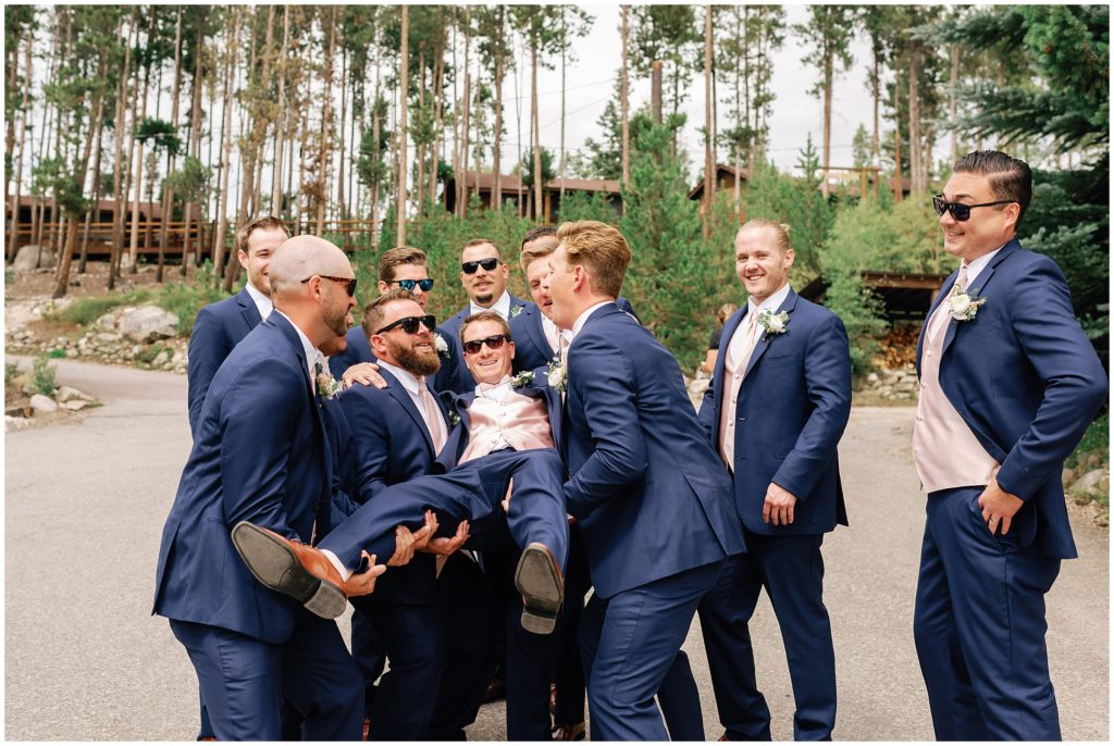 Groomsmen carrying groom at Grand Lake Lodge.