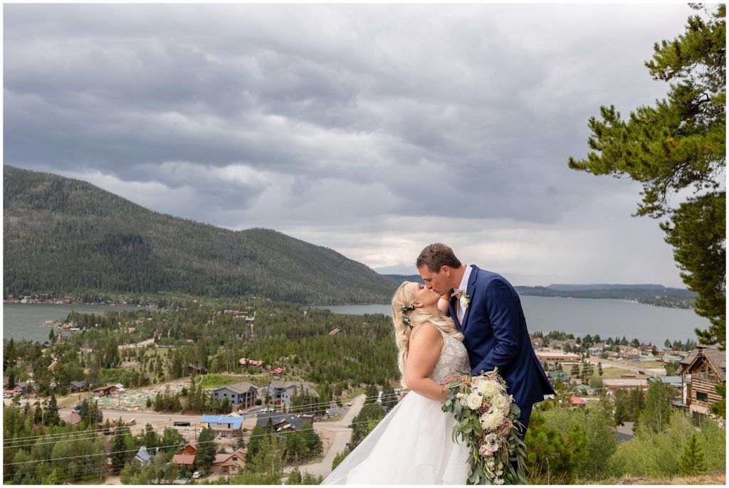 Bride and groom kissing after ceremony overlooking Grand Lake