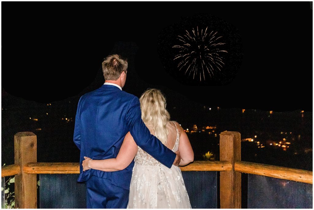 Bride and groom outside on patio at Grand Lake Lodge watching fireworks
