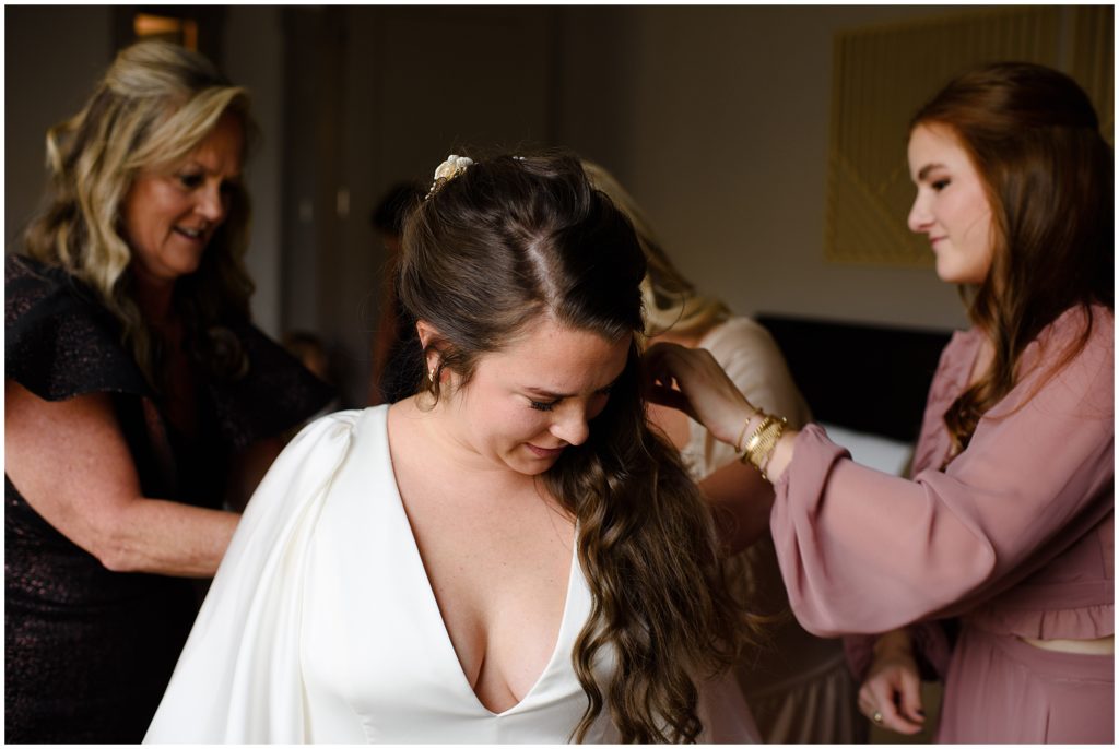Bride getting A&Be dress on for wedding