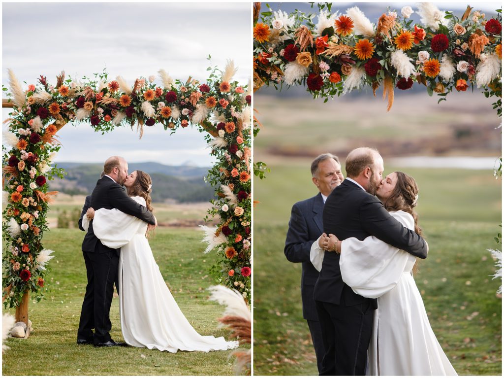 Bride and groom kiss under arch at wedding ceremony at Keystone Ranch