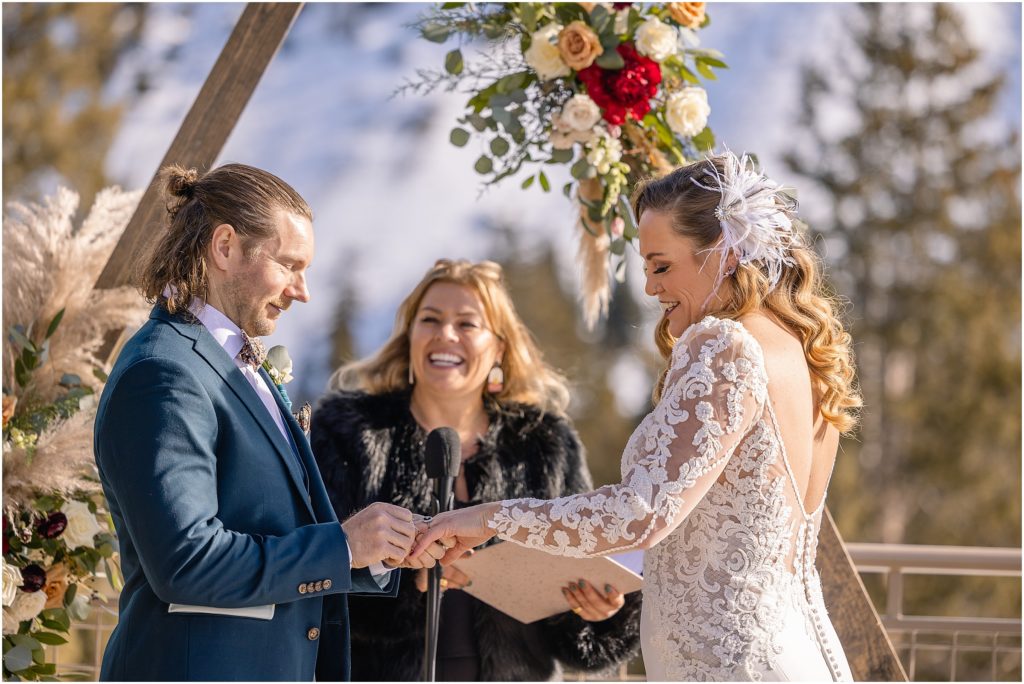 Bride and groom exchanging rings during ceremony at Arapahoe Basin.