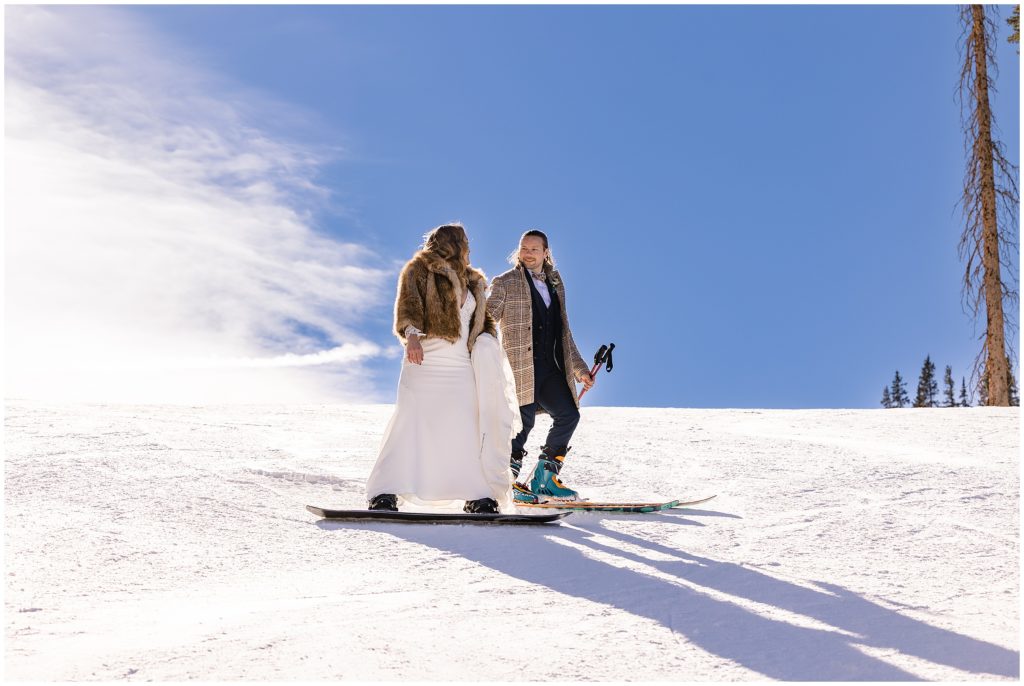 Bride and groom skiing down mountain at Arapahoe Basin after wedding ceremony
