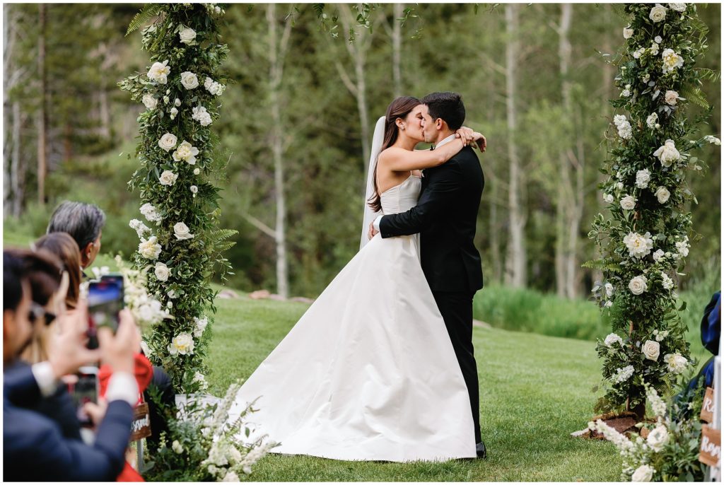 Groom and bride kissing at the end of wedding at Beano's Cabin