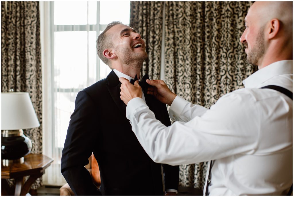 Groom getting tie fixed before wedding