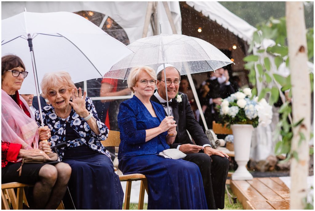 Guests holding umbrellas during rain for ceremony at Beano's Cabin in Beaver Creek