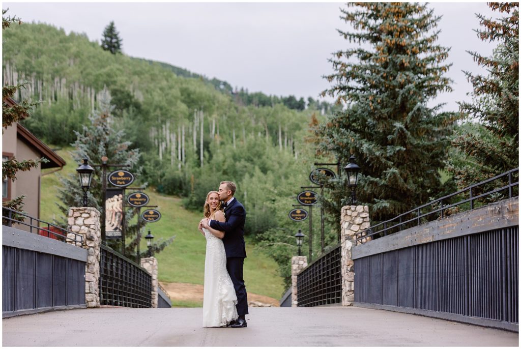 Bride and groom on bridge at Beaver Creek
