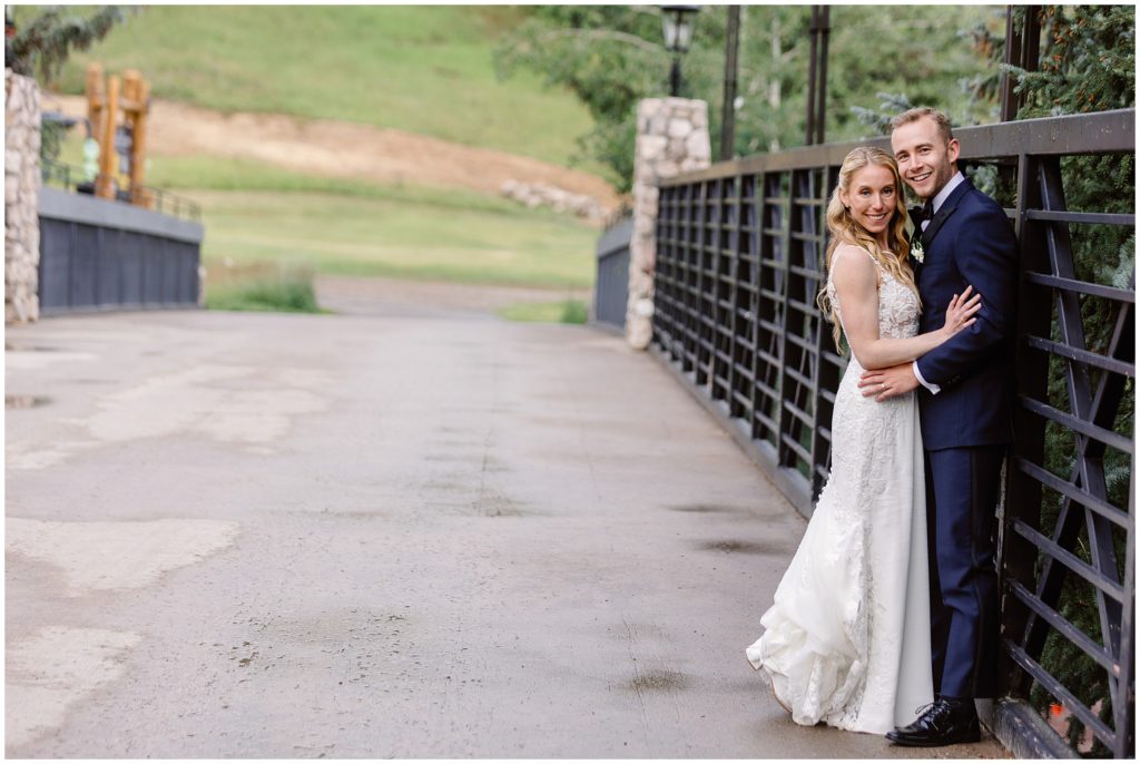 Bride and groom on bridge at Beaver Creek