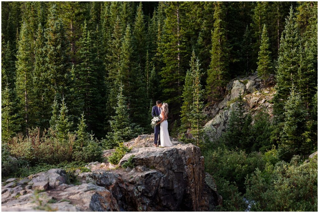Bride and groom near cliff at Blue Lake in Breckenridge