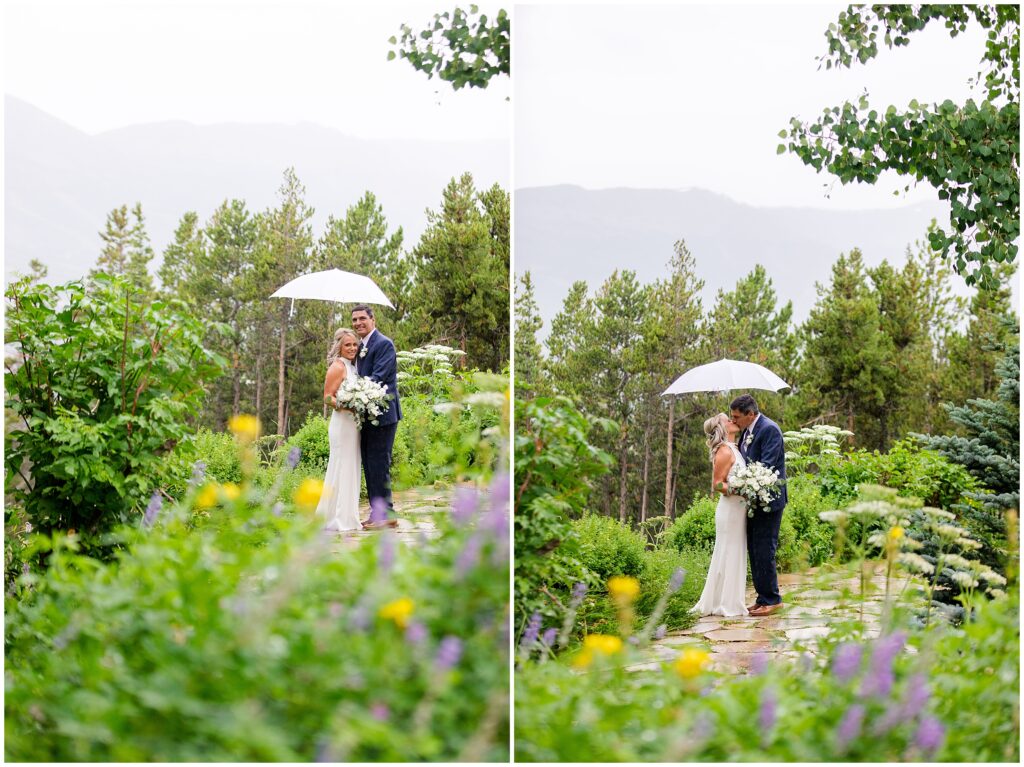 Bride and groom standing under umbrella with rain