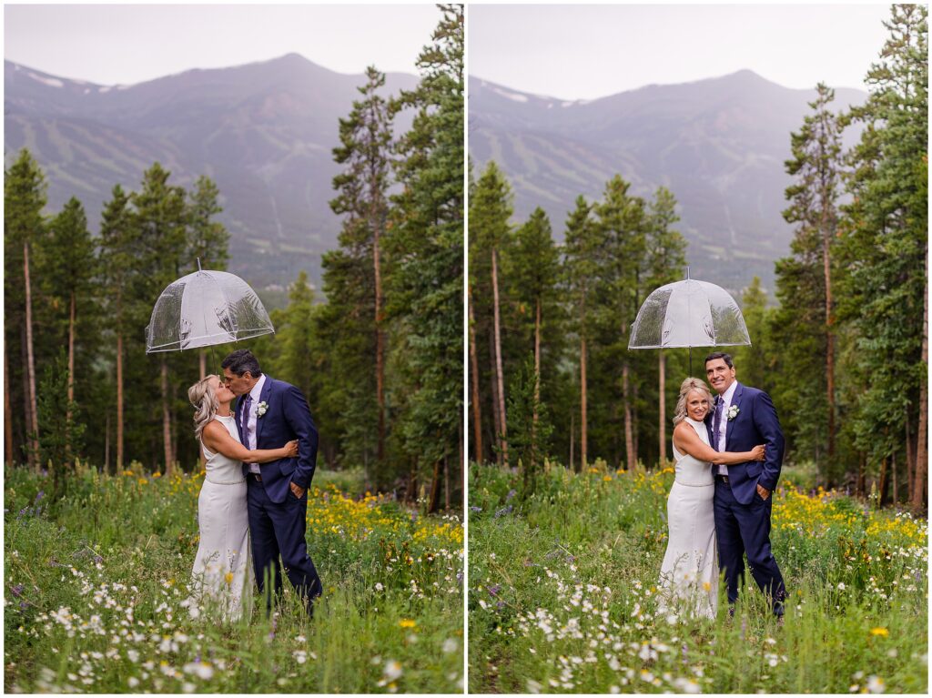 Bride and groom standing under umbrella with rain