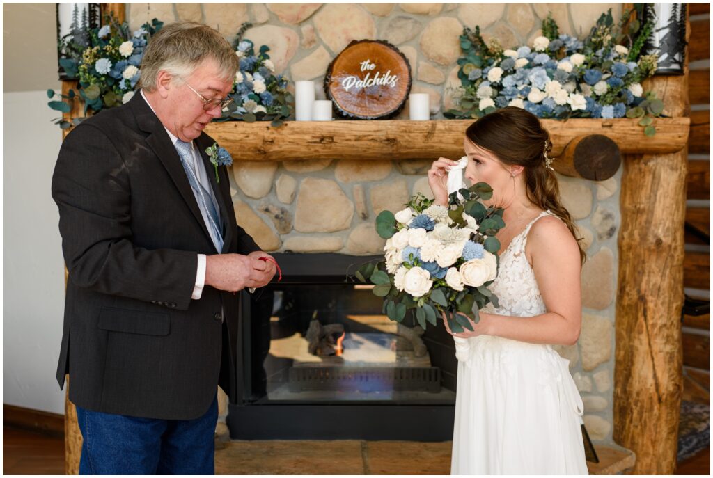 Bride wiping tears during first look with dad