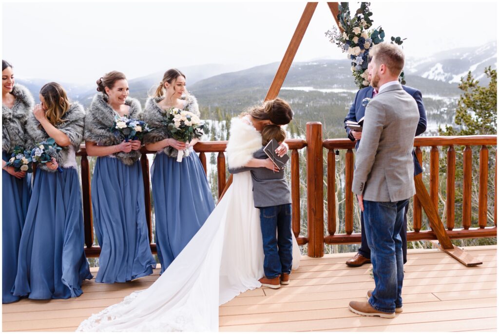 Bride hugging groom's son during ceremony at The Lodge at Breckenridge