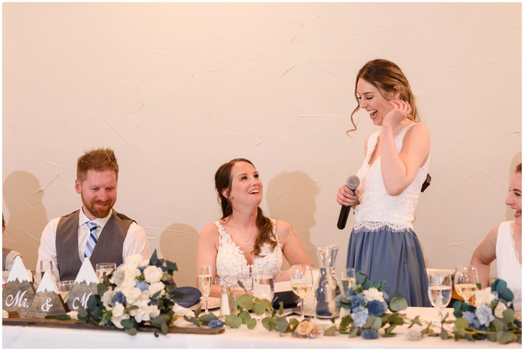 Bride laughing during speech from bridesmaid