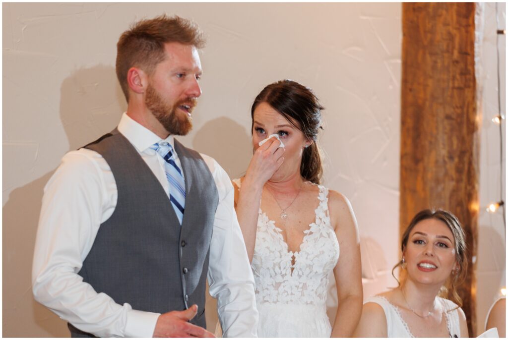Bride wiping tears during speech at reception