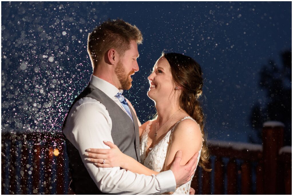 Bride and groom outside with snow coming down at The Lodge at Breckenridge