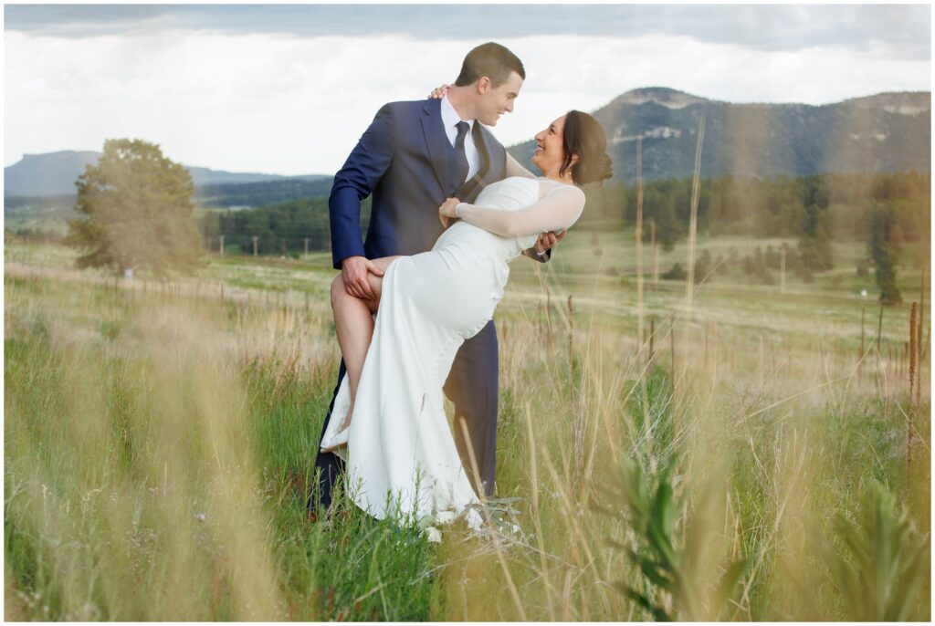 Bride and groom dancing in the tall grass