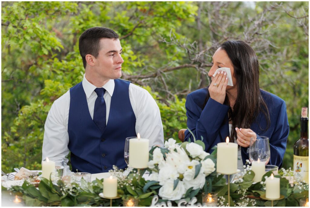 Bride wiping away tear during speeches at reception
