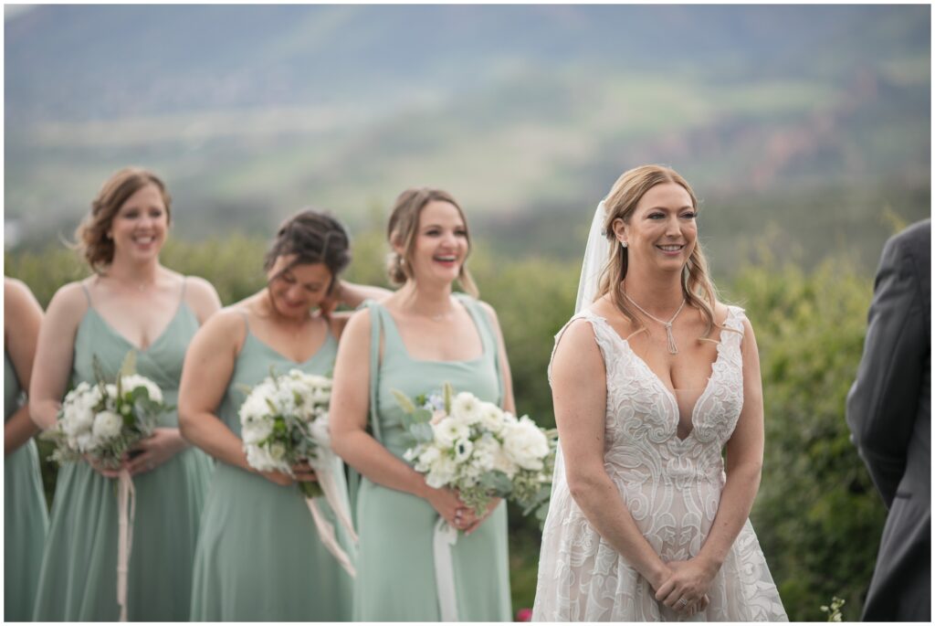 Bride and bridesmaids smiling during ceremony