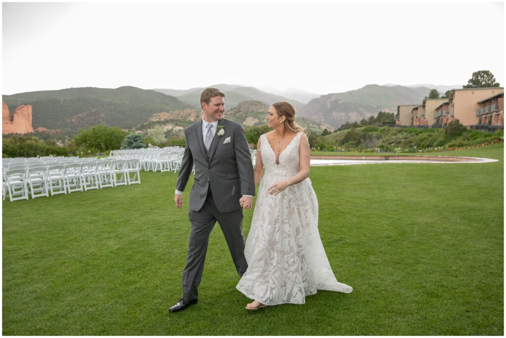 Bride and groom smiling and walking at Garden of the Gods Resort
