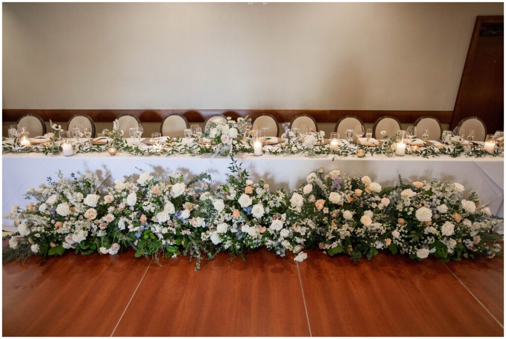 Bridal party table with floral arraignments designed by Little Shop of Floral