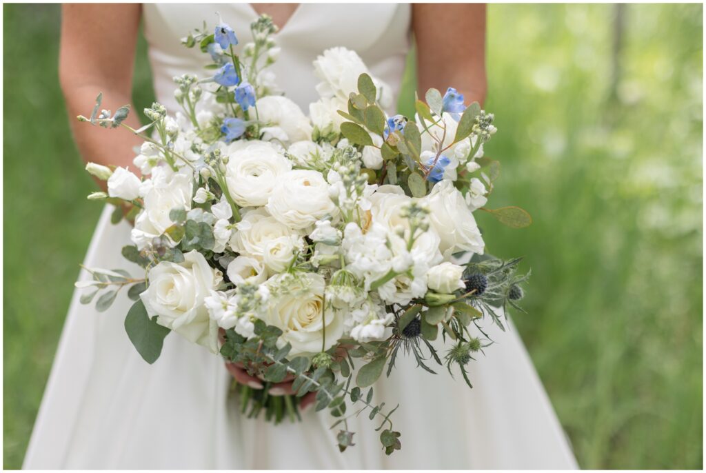 Bride holding bouquet designed by Bustle and Bloom