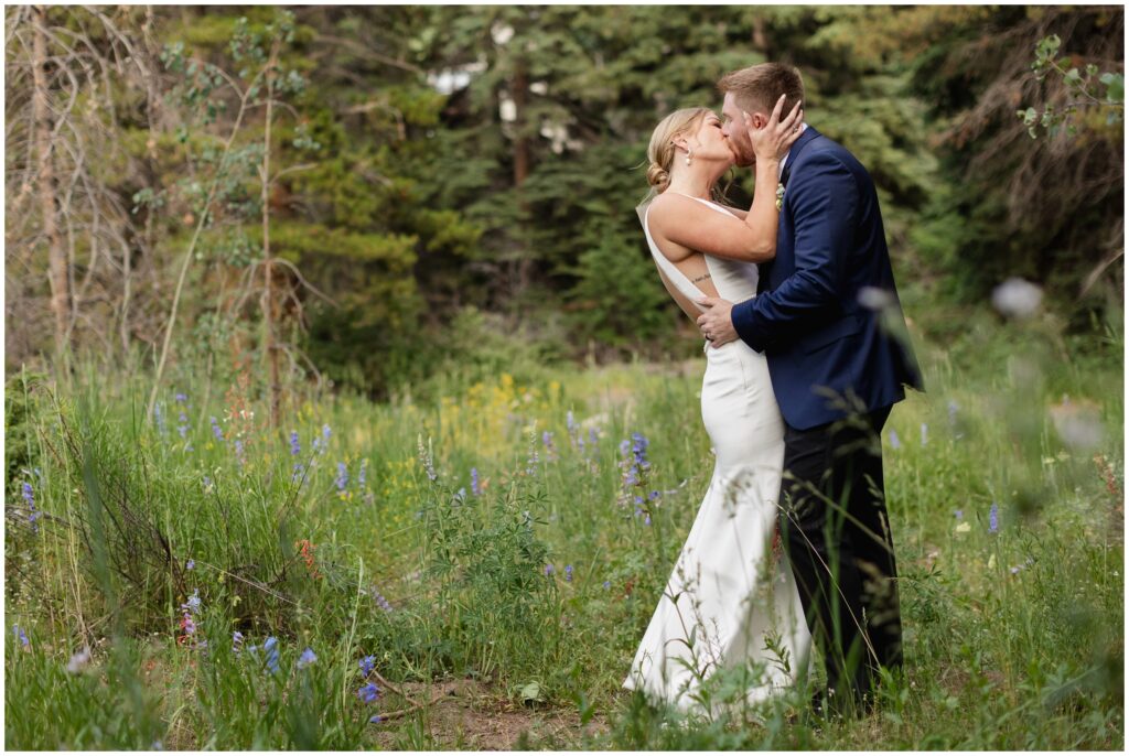 Bride and groom kiss on trail at Donovan Pavilion 