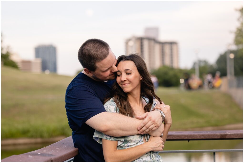 Couple hugging during Austin engagement session in front of lake