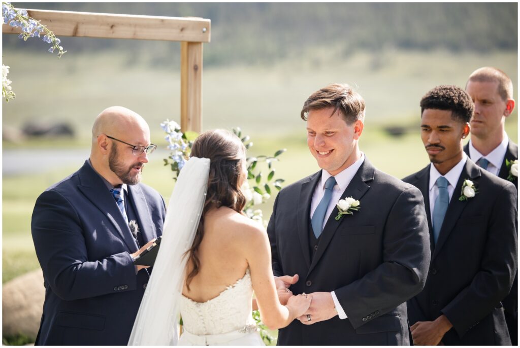 Groom smiling during ceremony at Keystone Ranch