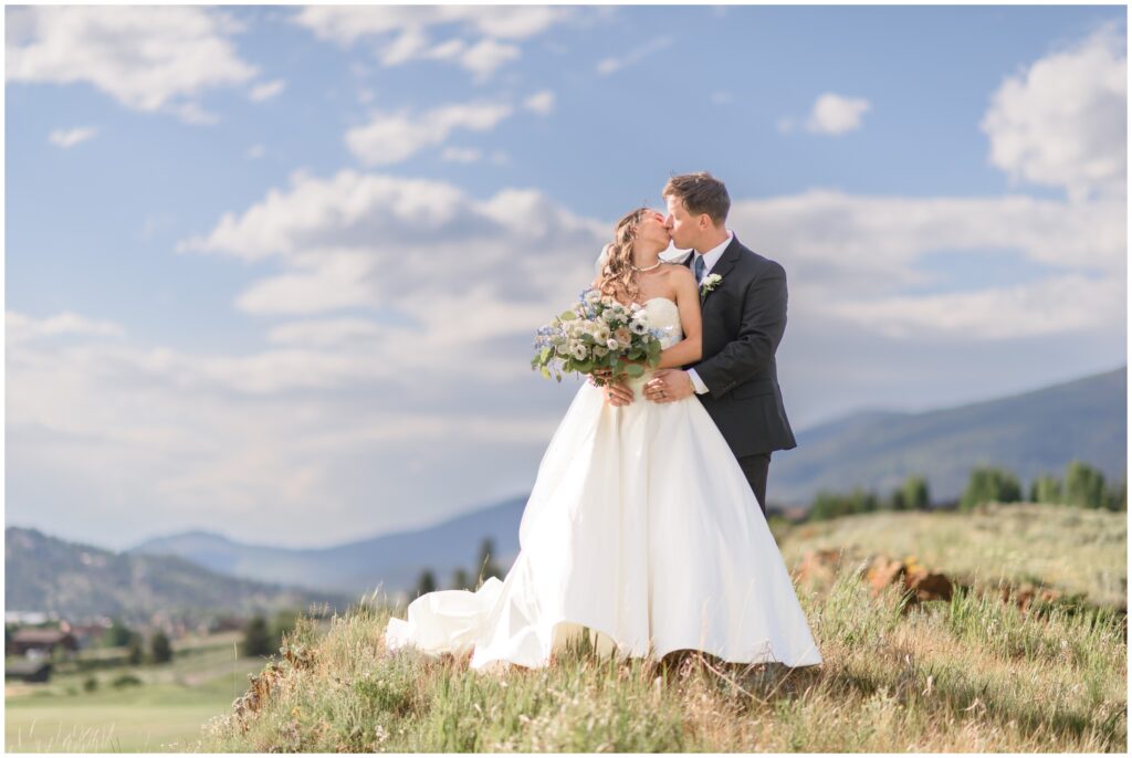 Bride and groom holding hands on hill at Keystone Ranch