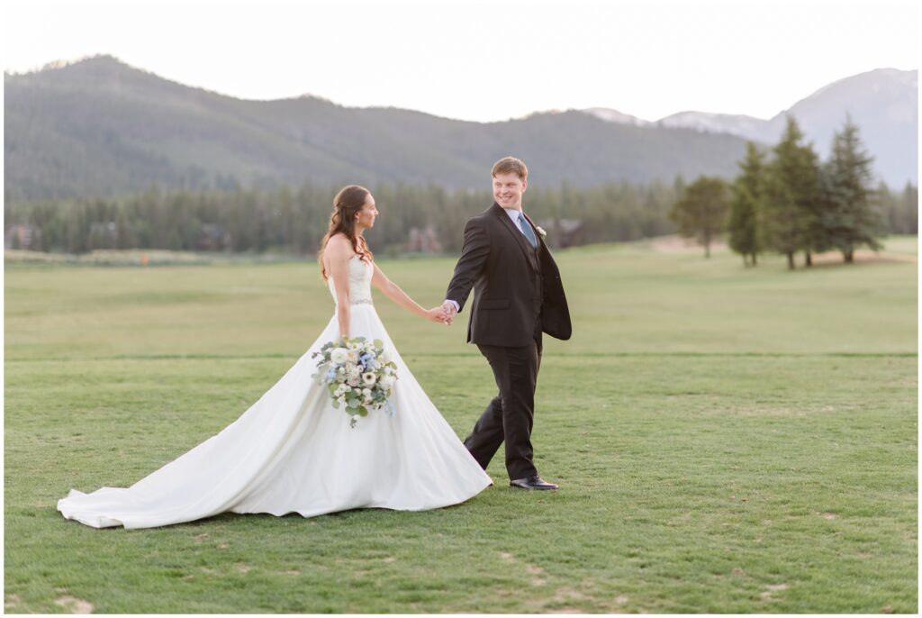 Bride and groom walking outside on grass at Keystone Ranch