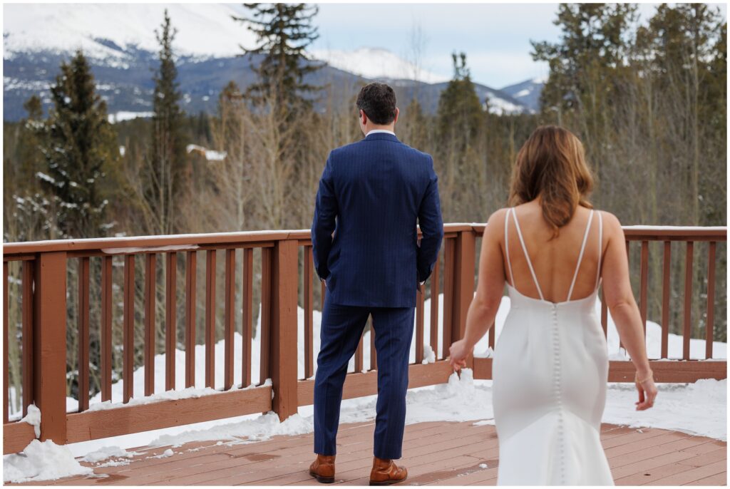 bride walking behind groom during first look at High Country Lodge Breckenridge
