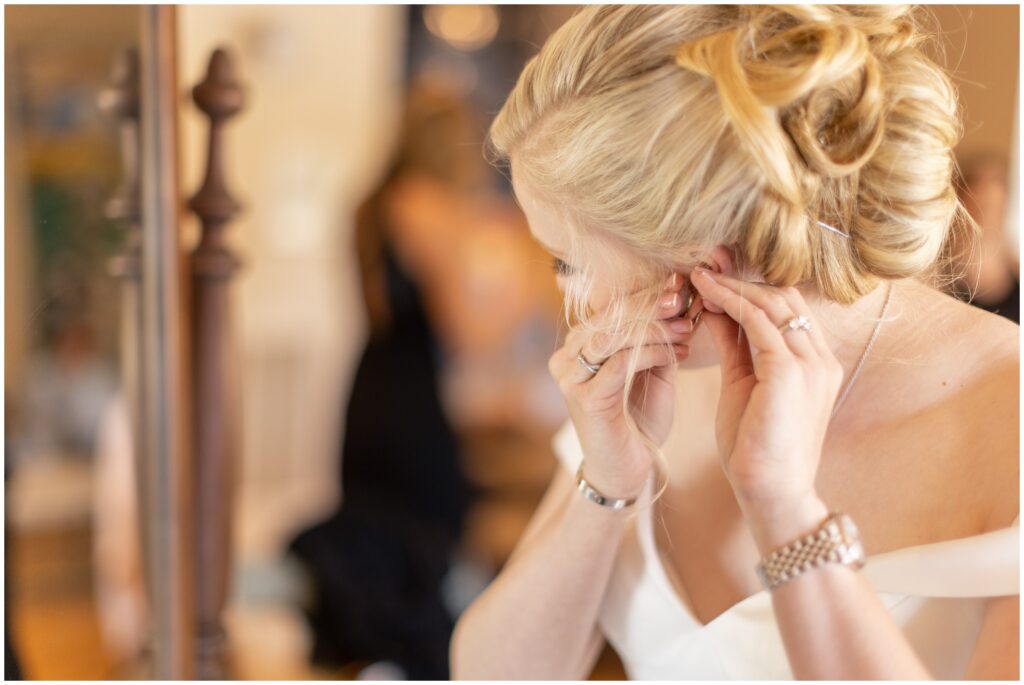 Bride putting on earrings