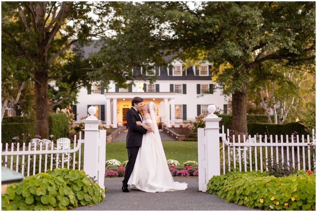 Bride and groom outside of gate at Woodstock Inn in Vermont