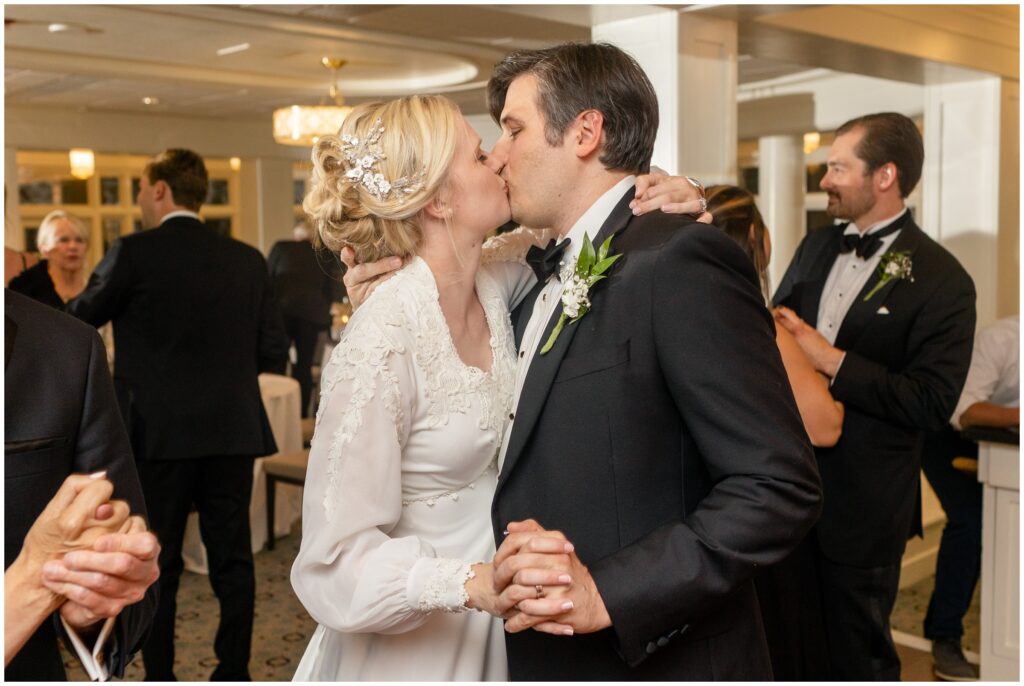 Bride and groom kissing during reception at Woodstock Inn in Vermont